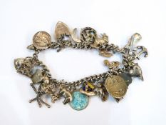 Silver-coloured metal charm bracelet with padlock clasp and a quantity of enamelled and other