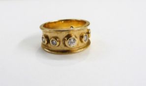 Gold coloured metal and diamond dress ring, having 7 collet set diamonds, raised edges,