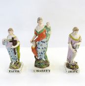 Set of three early 19th century pearlware figures of Faith, Hope and Charity, Faith holding cross,