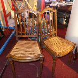 A pair of French side chairs with caned seats raised on reeded supports