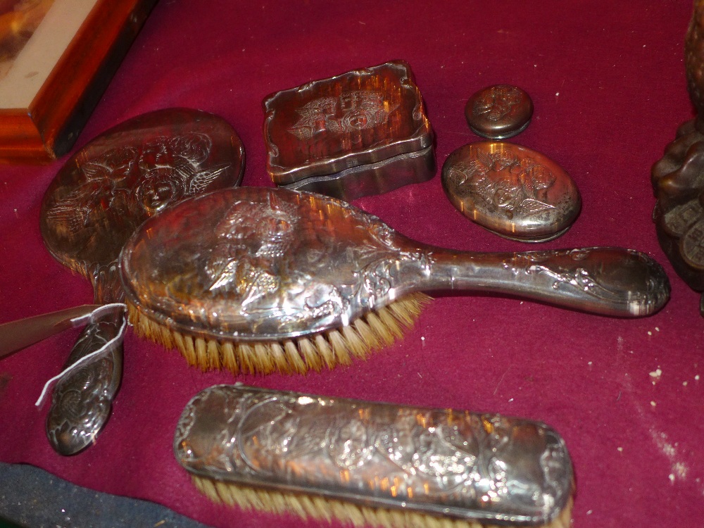 A William Comyns style hallmarked silver dressing table set having cherub detail in relief