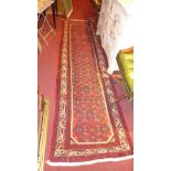 A fine north west Persian Malayer runner 285cm x 84cm with repeating Heratie motifs on a rouge field