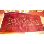 A fine North East Persian Turkoman rug, 200cm x 100cm, repeating ghoul motifs on a dark rouge