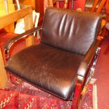 A retro designer armchair upholstered in black leather on chromed supports