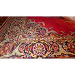 A central Persian Kashan rug 210cm x 140cm pendent medallion on a rouge field within stylised floral