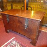 An 18th century oak coffer of smaller proportions with iron fittings and rising lid on bracket feet