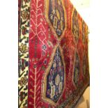 A fine north west Persian Afshar rug 205 x 135cm with repeating diamond medallion motifs on a rouge