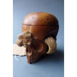 A carved hardwood skull and snake form lidded tobacco jar