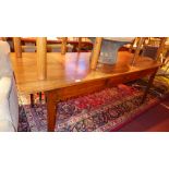 A vintage cherrywood farmhouse table the rectangular plank top above knife drawer and raised on