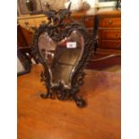 A Florentine style wall mirror with bevelled cartouche plate and ornate scrolling frame with