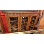 An oak bookcase, with a carved frieze over three glazed doors,