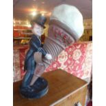 A 1930's Askeys Cake advertising figure in the form of a suited man in a top hat holding a giant