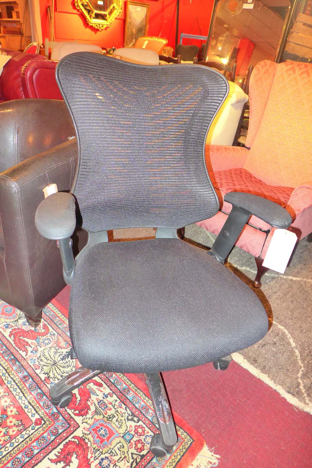 A black Hermann Miller style office chair raised on a swivel support