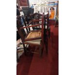 A set of four Hepplewhite mahogany dining chairs with hoop backs and drop insets on square tapering