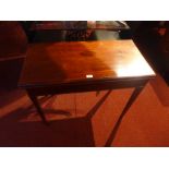 A 19th century mahogany tea table the foldover top raised on tapering supports