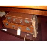 A tan leather vintage suitcase together