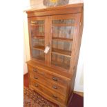 A pine dresser with two glazed doors ove