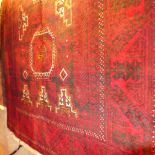 A fine North East Persian Turkoman rug 200cm x 100cm repeating goul motifs on a rouge field within