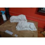 A pair of reconstituted marble figures of reclining lions,