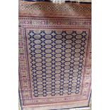 A Bokhara style carpet, having a blue fi