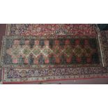 A fine north west Persian Senneh runner 280 x 95cm repeating stylised pole medallion on a rouge