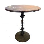 A cast iron pub table with turned column and twin dolphin support,