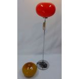 A vintage chromed standard lamp having a red glass shade together with an additional spare shade,