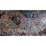 A large Persian carpet having a medallion on a midnight blue field decorated with ewers,