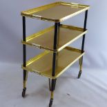 A gilt and ebonised drinks trolley with three tiers raised on castors
