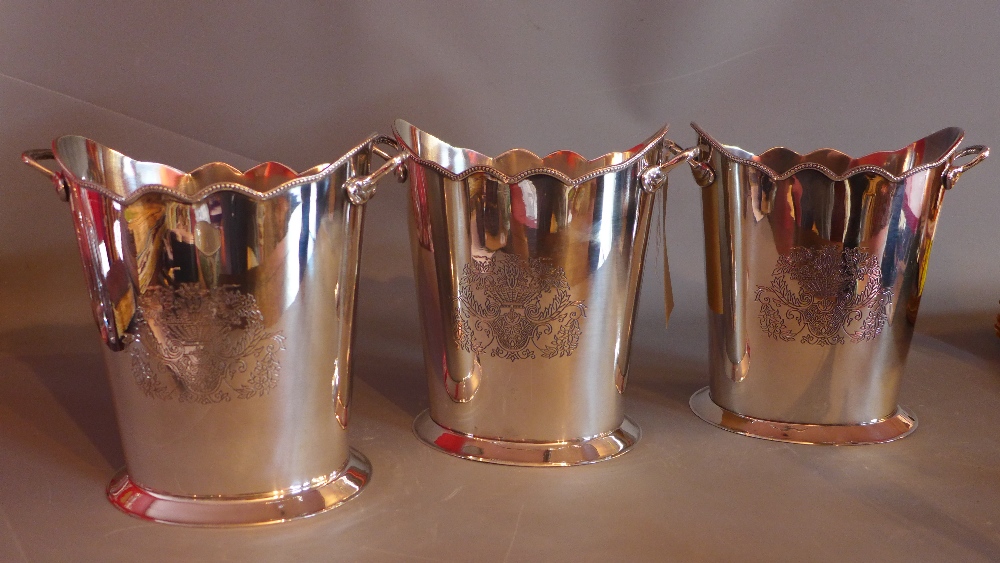 A set of three oval and etched silver plated wine coolers