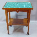 An Arts and Crafts tiled top oak occasional table having an under tier H 78 x W 65 x D 50cm