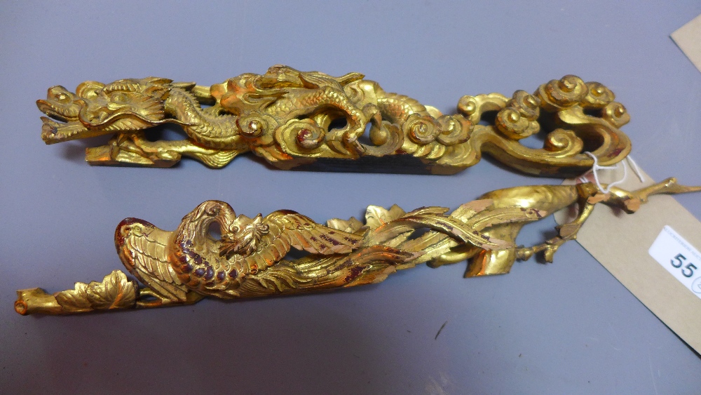 A pair of Chinese giltwood carvings depicting a dragon and a phoenix W 34cm