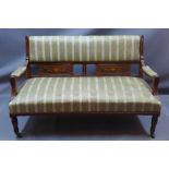 An Edwardian satinwood inlaid mahogany two seater salon sofa raised on turned legs and castors,