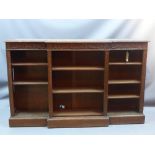 An early 20th century oak breakfront open bookcase with carved features and adjustable shelves,