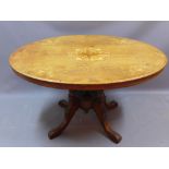 A Victorian mahogany oval tilt top table with marquetry inlay to top and raised on turned supports