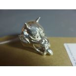 A silver ring in the form of a Japanese mythical creature with ruby eyes.