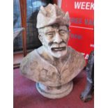 A reconstituted stone bust of a man with a feather in his hat (af) H 50cm