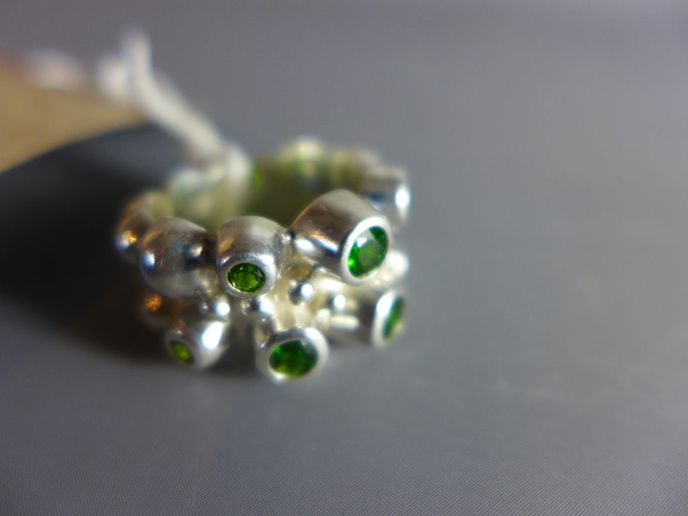 A nobbly silver ring set with diopside stones.