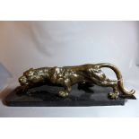 A 20th Century bronze sculpture of a jaguar, raised on a marble base.