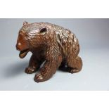 A carved wood figure of a bear with bone