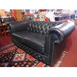 A Chesterfield style two seater sofa wit