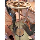 A brass stick stand on a cast iron base,