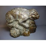 An unusual stone carving of a chameleon perched on a man's head.