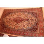 A Persian Kashan rug having a medallion on an ivory field with blue spandrels,