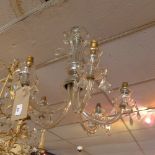 A glass five branch chandelier, the drip trays hung with lustres,