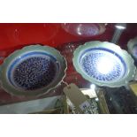 A pair of Chinese dishes having Celadon ground with blue and white floral design to centre,