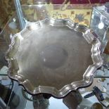 A Mappin & Webb silver salver with scalloped rim and raised on scroll feet.