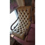 A mahogany and tan leather slipper chair, having buttoned seat and back with studded edges.