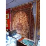 A Keshan style carpet with central floral medallion surrounded by vines on a beige field and