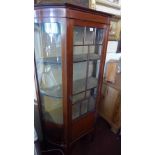 A Edwardian mahogany bow fronted display cabinet, raised on square tapered legs and spade feet.